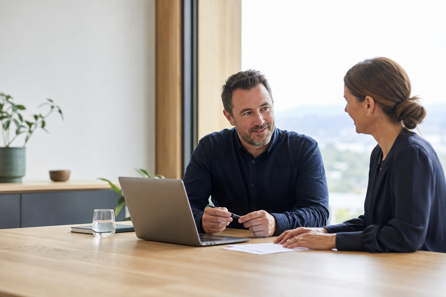 Two business people having a calm conversation in a bright office
